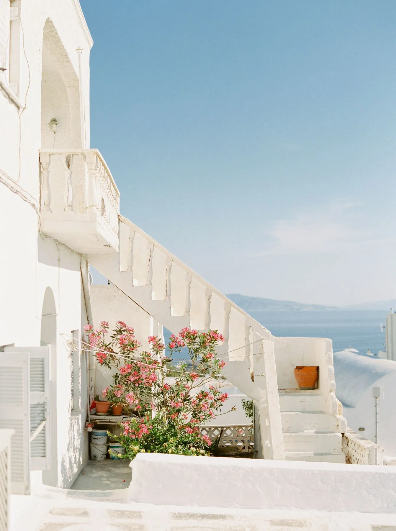 white building with flowers in front of it in Greece