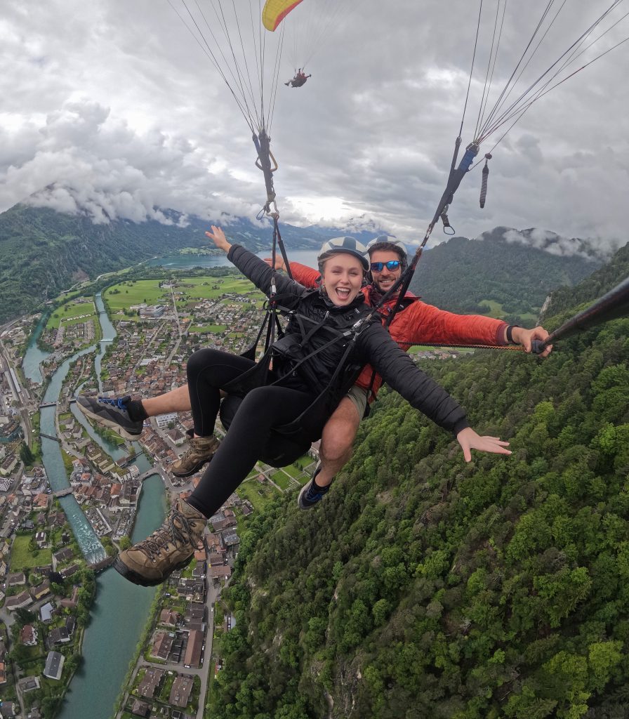Female founder mid-paragliding excursion in Switzerland