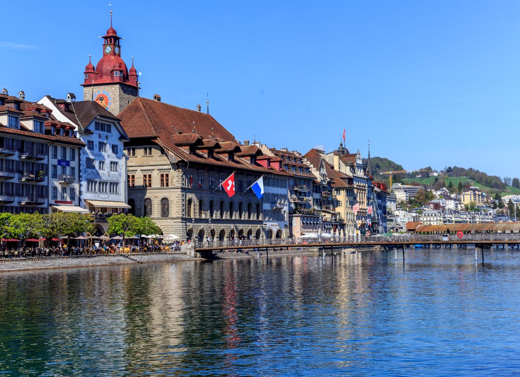 Charming cityscape of Lucerne, Switzerland, showcasing historic buildings and waterfront reflections.
