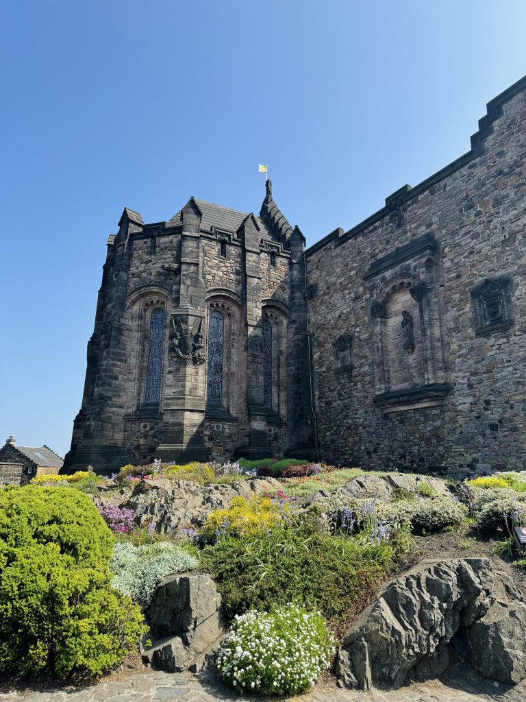 Edinburgh castle's stone walls with a garden in front of it