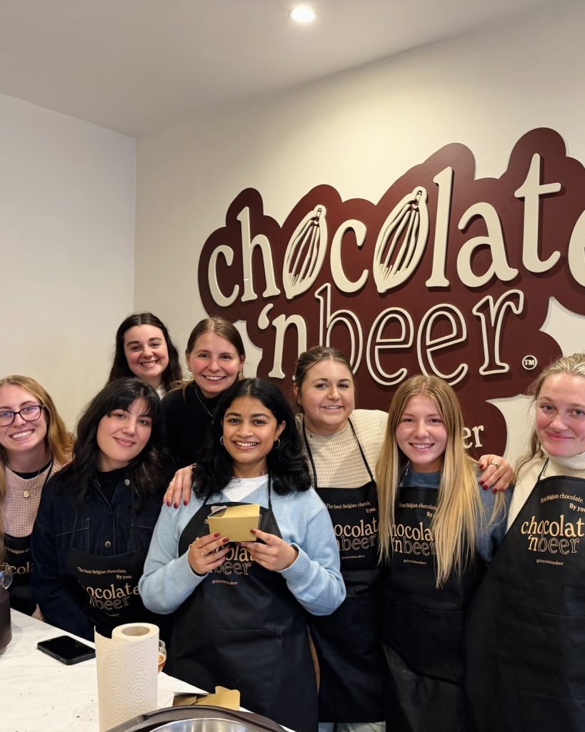 A group of girls pose for a picture with their homemade chocolates from a chocolate and beer class in Bruges Belgium