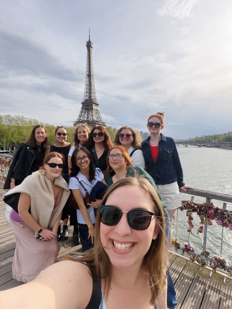 A group of women pose for a selfie in front of the Eiffel Tower in Paris